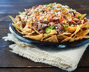 Carne Asada Super Chips with Beans, Guacamole, Cheese, Salsa and Meat