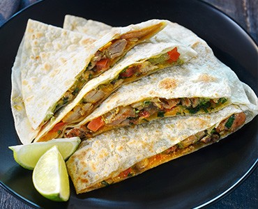 Super Quesadilla Filled with Cheese, Chicken, Onions, Cilantro, and Tomatoes